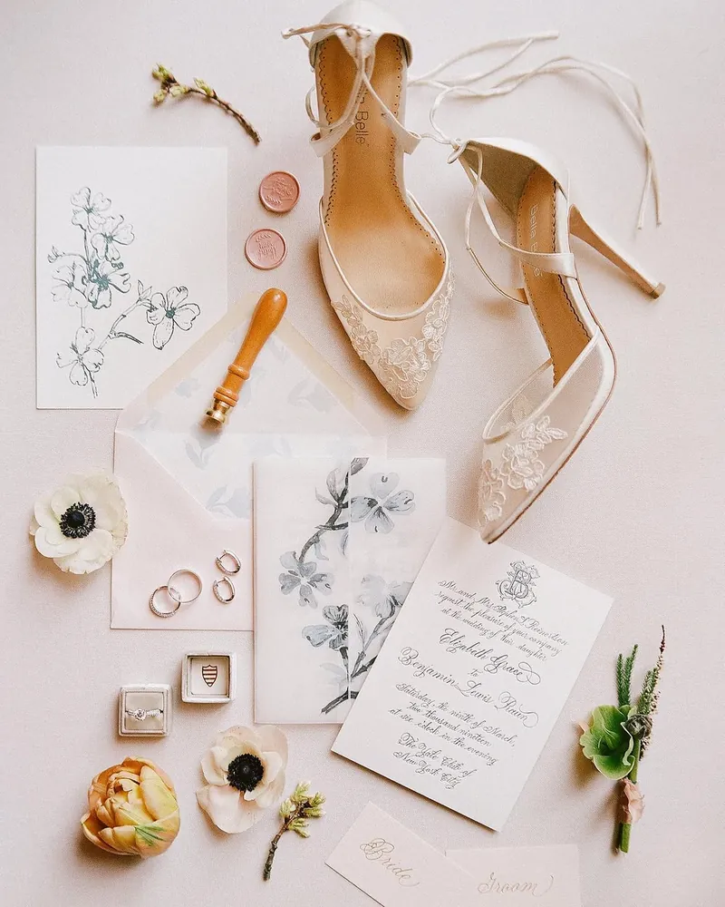 Botanical sketch invitation suite with a copper wax seal, anemones, and lace bridal heels
